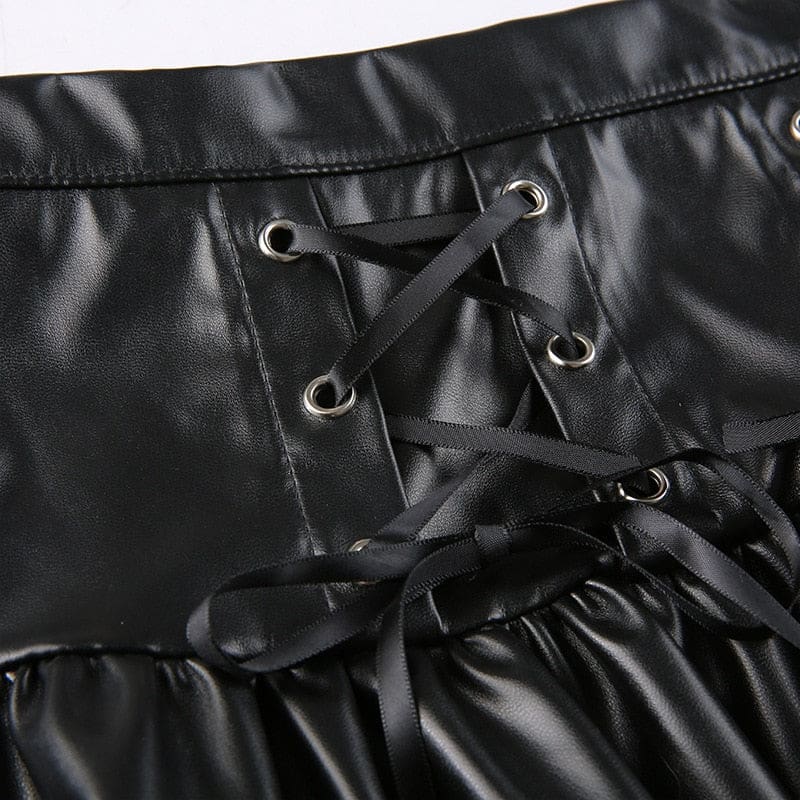Close-up of black ribbon threaded through silver-tone eyelets in the two front panels of the faux leather skirt.