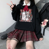 Black Menhera bear graphic hoodie worn in a seated outfit with the front print visible.