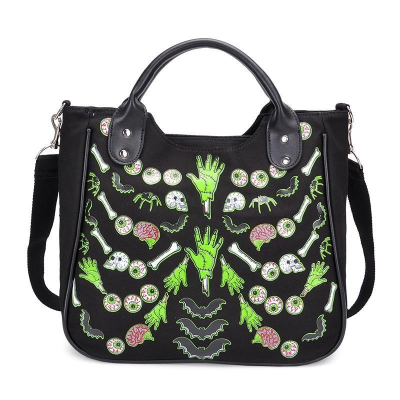 Black Monster Mash handbag with rounded top handles and a symmetrical print of green hands, eyeballs, pink brains, bones and bats across the front.