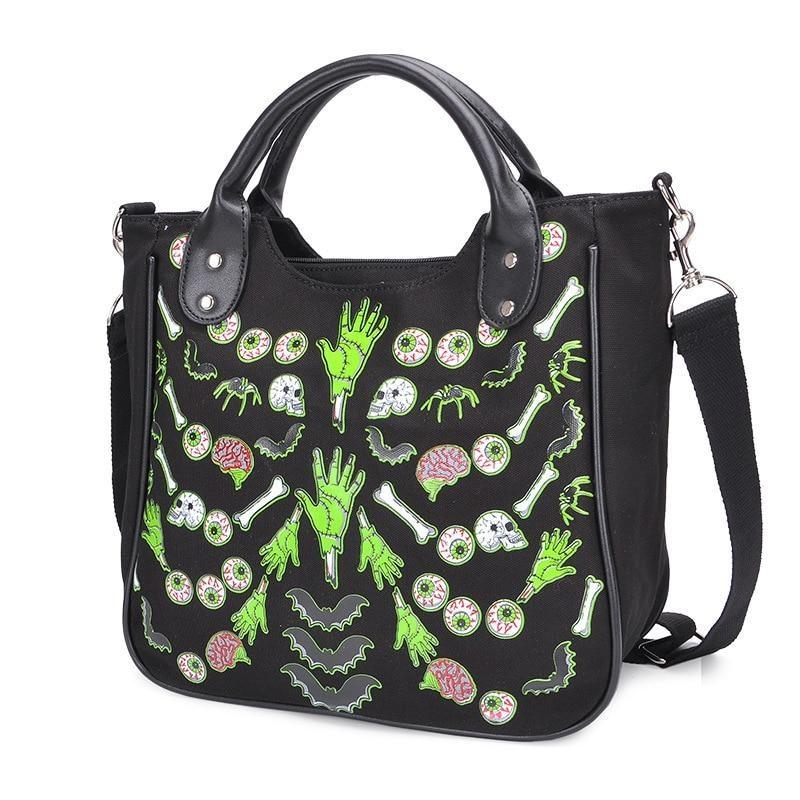 Angled view of the black monster-print handbag, showing the structured side, twin top handles and long black shoulder strap beside the illustrated front.