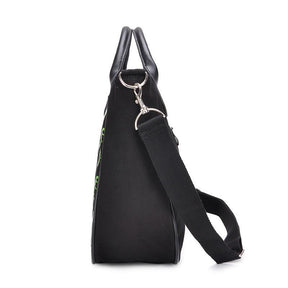 Side view of the black gothic handbag with its broad triangular profile and metal clip attaching the adjustable shoulder strap to a side ring.