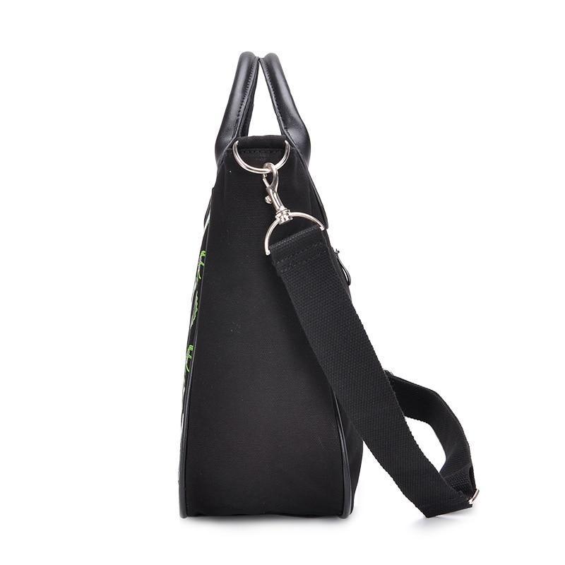 Side view of the black gothic handbag with its broad triangular profile and metal clip attaching the adjustable shoulder strap to a side ring.