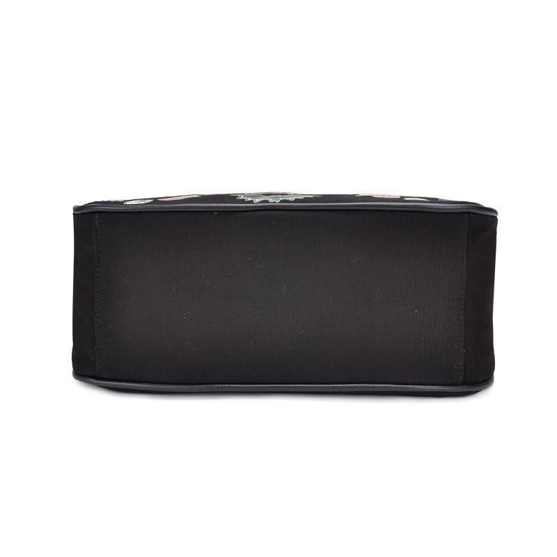 Underside of the black Monster Mash handbag, showing the broad plain rectangular base and edge seams against white.