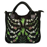 Front photograph of the black Monster Mash handbag with green hands, eyeballs, bones and pink brains visible below the curved handles.