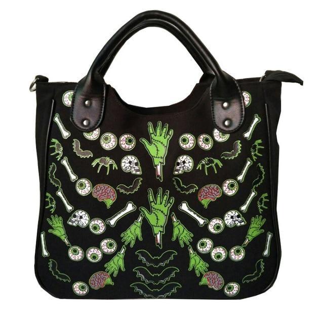 Front photograph of the black Monster Mash handbag with green hands, eyeballs, bones and pink brains visible below the curved handles.