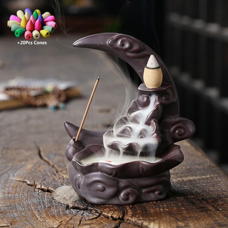 Black crescent moon backflow burner with a dark plum-toned finish and sculpted scroll details, shown with smoke and a 20-cone graphic.