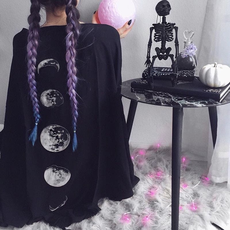 Moon phase print on a black shawl in a celestial outfit with purple braids.