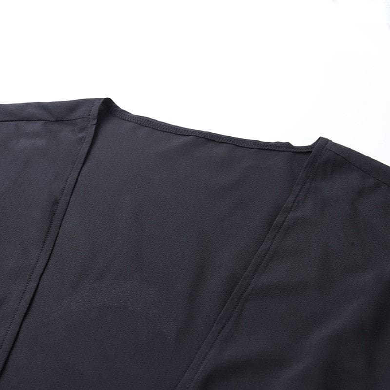 Close-up of the plain neckline seam and front edge of the black draped shawl.