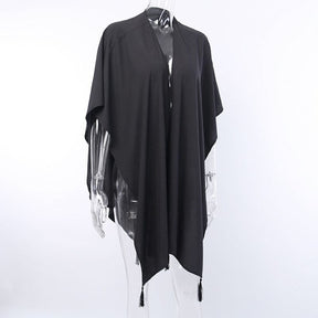 Black shawl on a clear mannequin, showing the open front and hanging tassel points.