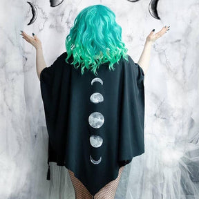 Wide draped shape of the black moon phase shawl shown with the wearer's arms lifted.