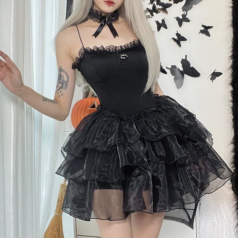 Square angled view of the black moon-charm dress with one hand raised beside the neckline.