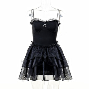 Black moon-charm mini dress on a mannequin, showing its thin straps and tiered ruffle skirt from the front.
