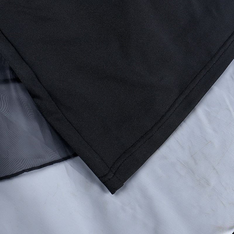 Detail of the black dress’s opaque shorter underlayer beneath the sheer outer ruffles.