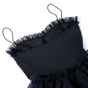 The reverse of the black dress bodice laid flat, showing its seams and smooth fabric.