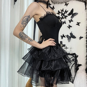 Square side outfit view of the black dress showing the layered ruffles below the fitted waist.