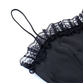 Close-up of a thin black shoulder strap beside the lace-trimmed neckline.