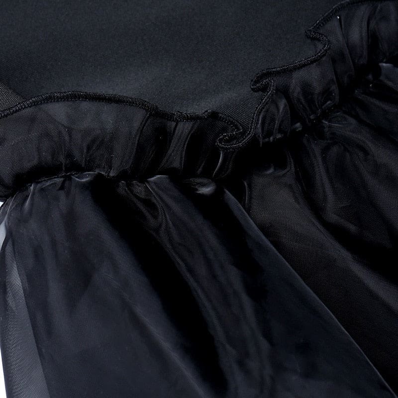 Detail of the black dress waist seam where the fitted bodice meets the layered skirt.