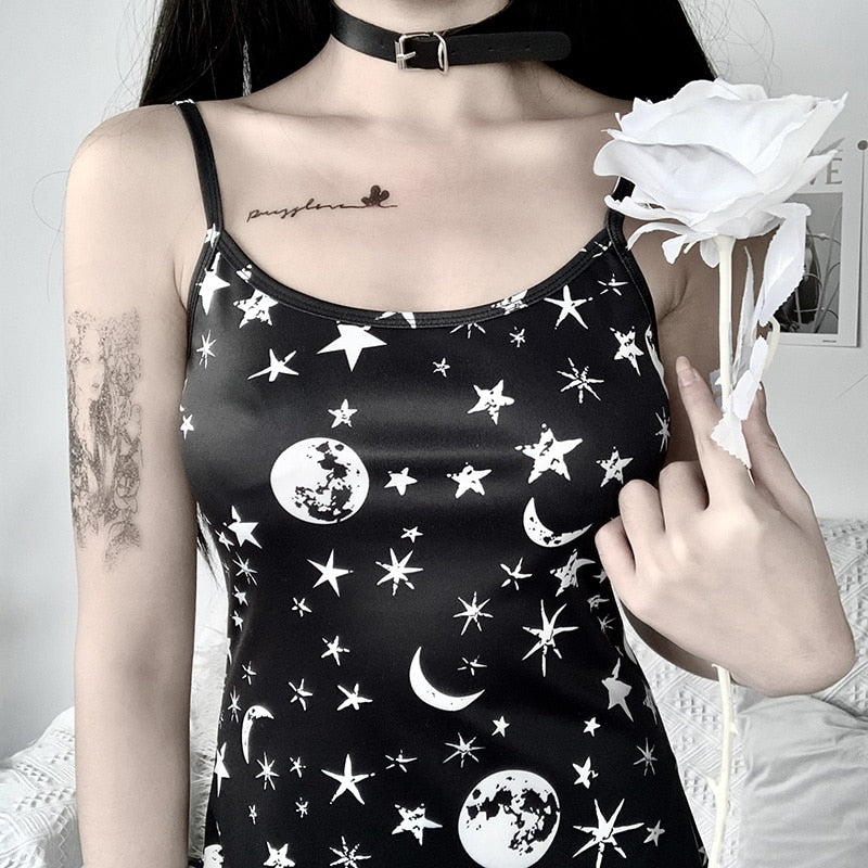 Black moon and star print mini dress with a close worn view of the neckline and celestial print.