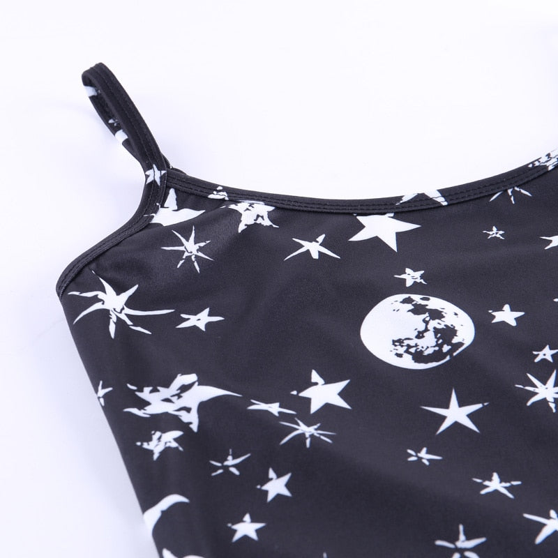 Black moon and star print mini dress with a close view of a strap and the neckline.
