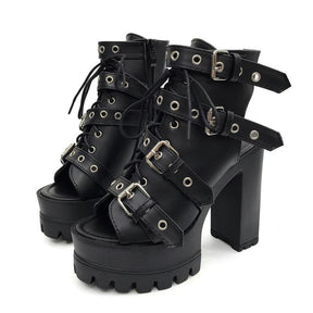 Pair of black open-toe platform booties with four eyelet buckle straps, lace-up fronts and separate high block heels.