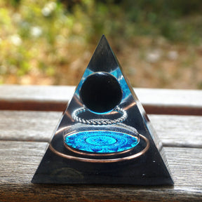 Additional view of Black obsidian orgone pyramid with a dark sphere, blue mandala and copper loops. Another front view on wood shows the sphere above the blue mandala.
