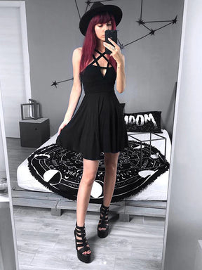 Mirror outfit view of the black pentagram dress with a separate hat and strappy shoes in a gray bedroom, showing the fitted waist and short flared hem.