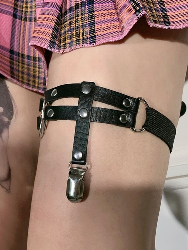 Side and rear view of the black thigh garter worn under a skirt, showing the elastic back straps and rectangular sliding adjuster.