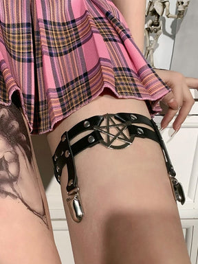Angled close view of a silver-tone pentagram ring at the front of the black thigh garter, with two clips hanging toward the stocking top.