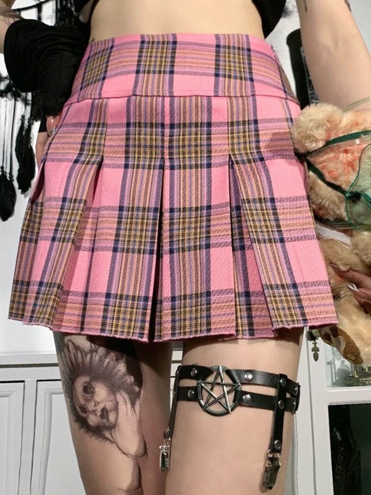 Pentagram thigh garter styled with a pink plaid skirt and dark stockings, showing the black parallel bands and hanging clips below the hem.