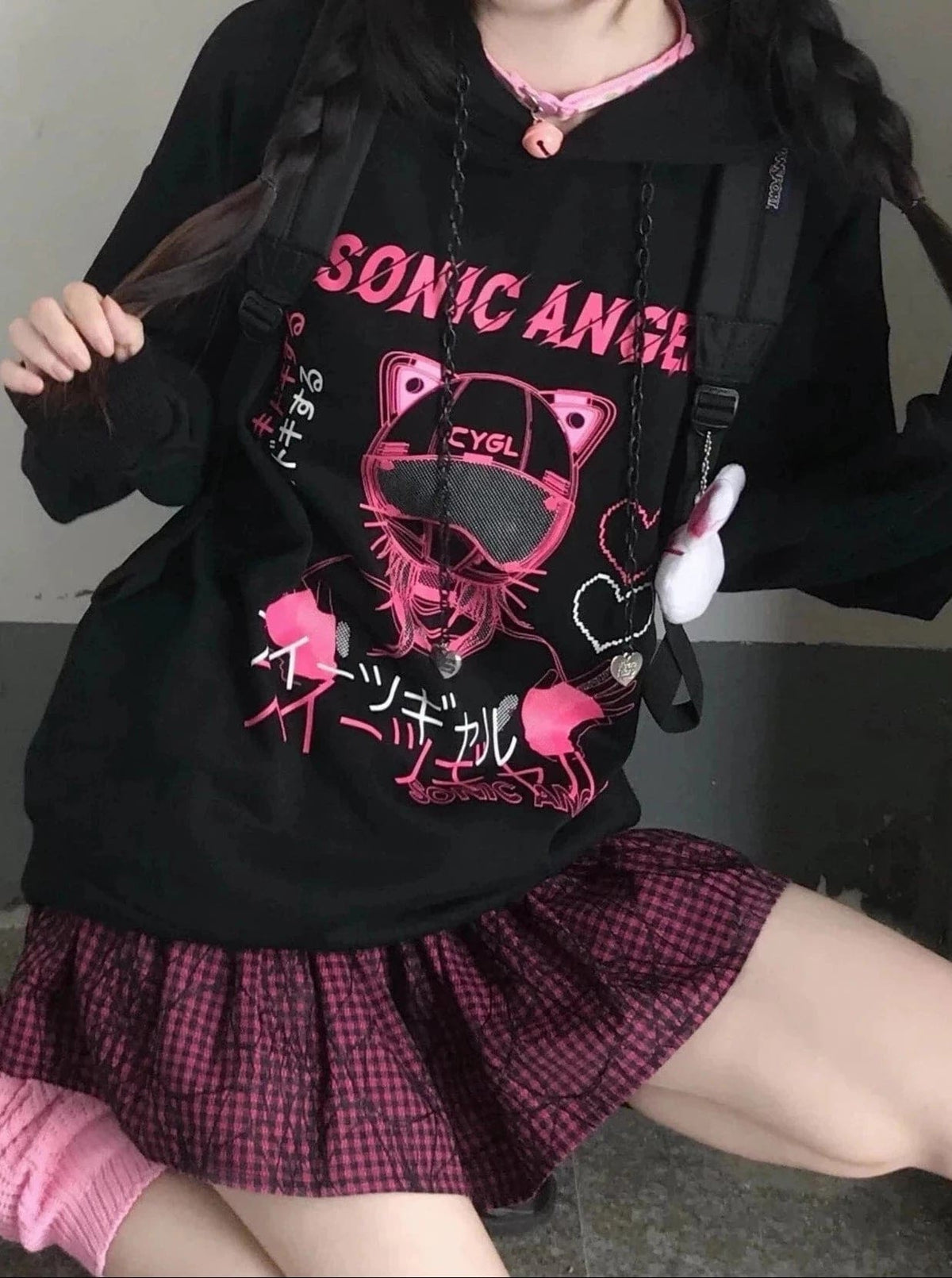 Black hoodie with a pink cat-ear helmet graphic and outlined hearts, shown with a bag strap across the front.