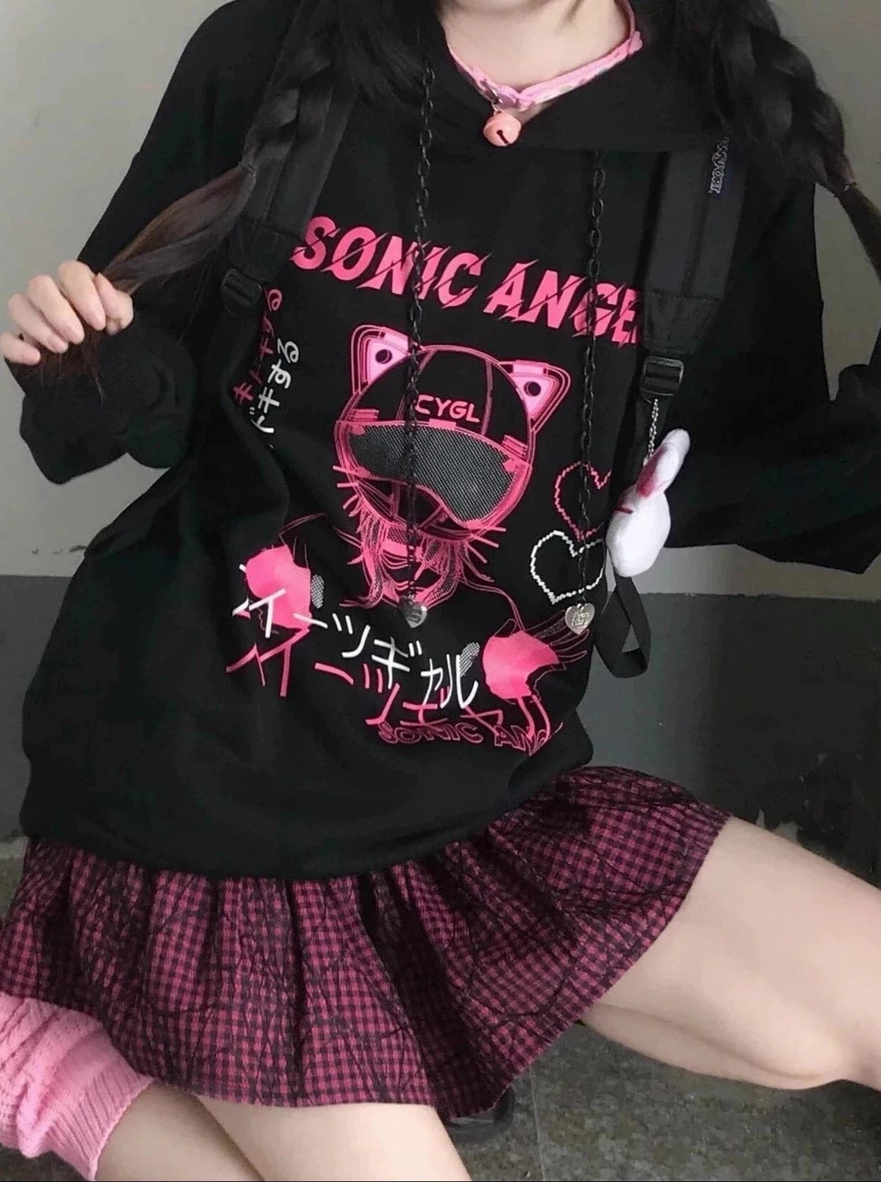 Black hoodie with a pink cat-ear helmet graphic and outlined hearts, shown with a bag strap across the front.