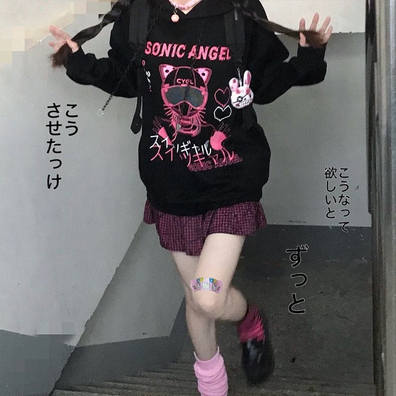 Square outfit view of the black graphic hoodie and pink plaid skirt with Japanese advertising text around the model.