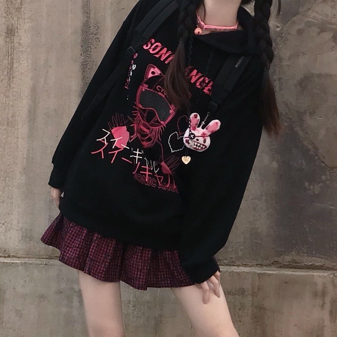 Portrait crop of the black hoodie from an angle, showing the pink graphic above a plaid skirt.