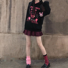Full outfit view of the black and pink hoodie over a plaid skirt, with striped socks and platform shoes.