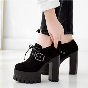 Black buckle platform booties worn with cropped dark jeans, showing the low ankle opening, short laces and tall separate block heels.