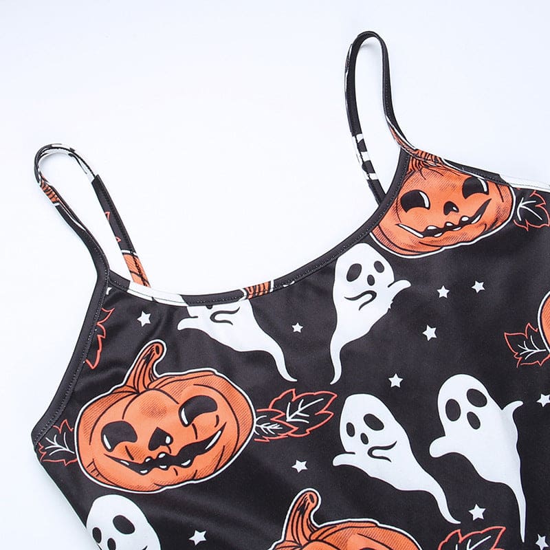 Flat close-up of the dress’s curved front neckline, edged in black beside orange pumpkins, white ghosts and small stars.