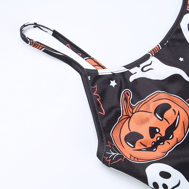 Close view of a narrow black shoulder strap and the bound armhole edge on the pumpkin-and-ghost dress.