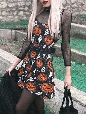 A model leans beside a stone wall in the black pumpkin-and-ghost dress, carrying a black bag and showing the short skirt at an angle.