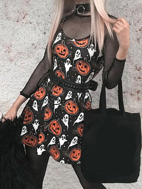 Front outfit view of the black pumpkin-print mini dress worn with a mesh underlayer, belt and black handbag outdoors.