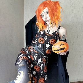 Seated full view of an orange-haired model in the Halloween skater dress with a pumpkin, showing the orange and white print across the short skirt.