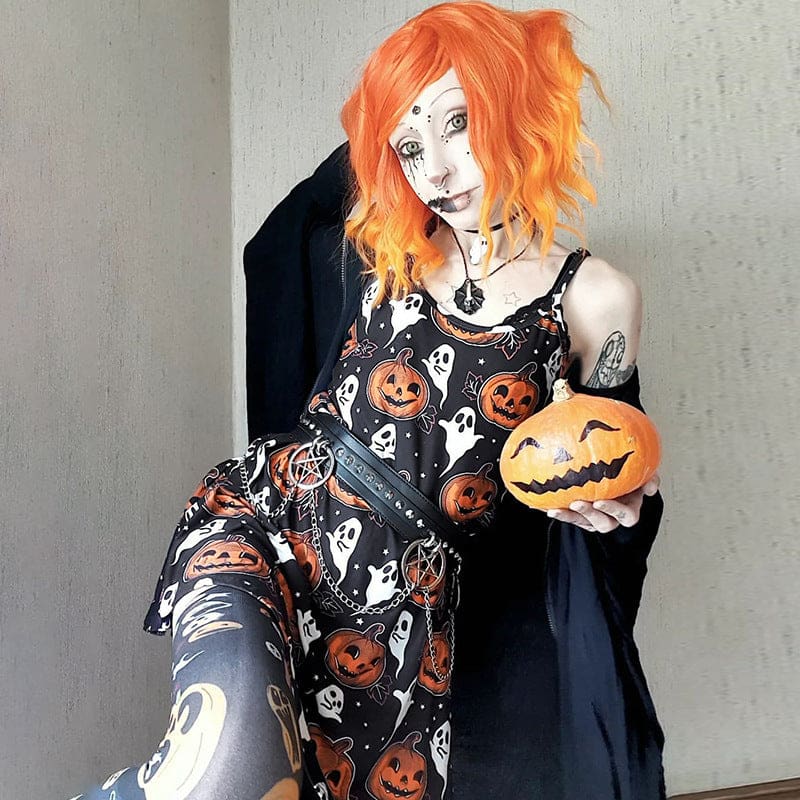Seated full view of an orange-haired model in the Halloween skater dress with a pumpkin, showing the orange and white print across the short skirt.