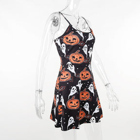 Angled view of the black Halloween skater dress on a clear mannequin, showing the narrow straps and orange pumpkin print along the side.