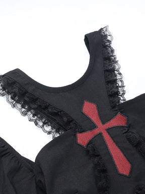 Close-up of the red cross on the black chest panel, with narrow lace ruffles bordering the curved neckline and open shoulder cutouts.