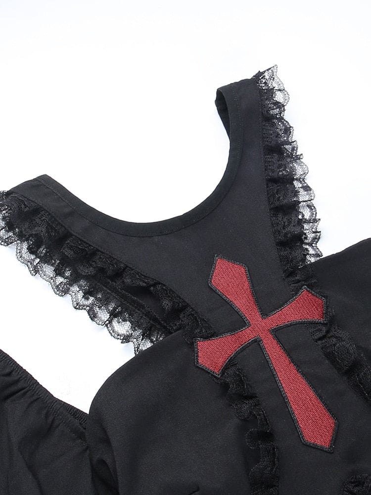 Close-up of the red cross on the black chest panel, with narrow lace ruffles bordering the curved neckline and open shoulder cutouts.