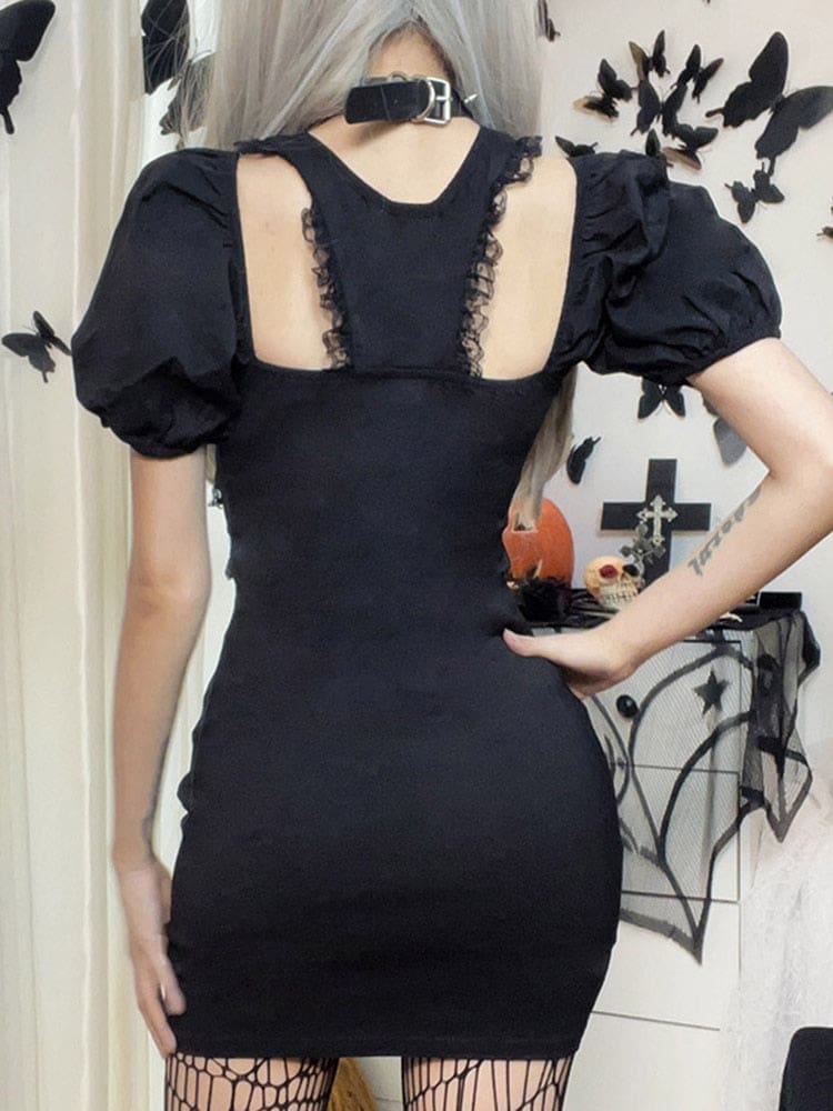 Rear view of the fitted black mini dress, showing a central upper-back panel edged with lace between two open cutouts and short puff sleeves.