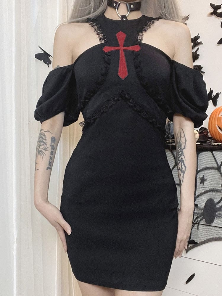 Straight-on view of the black Chapel dress worn off the shoulders, with a red cross centred between the open upper-chest sections.
