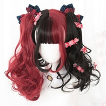 Black-and-red wig styled with voluminous curled side ponytails, contrasting face-framing strands and red patterned bows, displayed on a white mannequin.