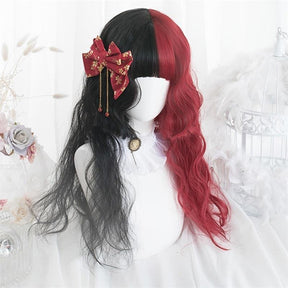 Black-and-red split-color wig with loose waves and full bangs, styled on a white mannequin with a red-and-gold bow and hanging ornaments at one side.