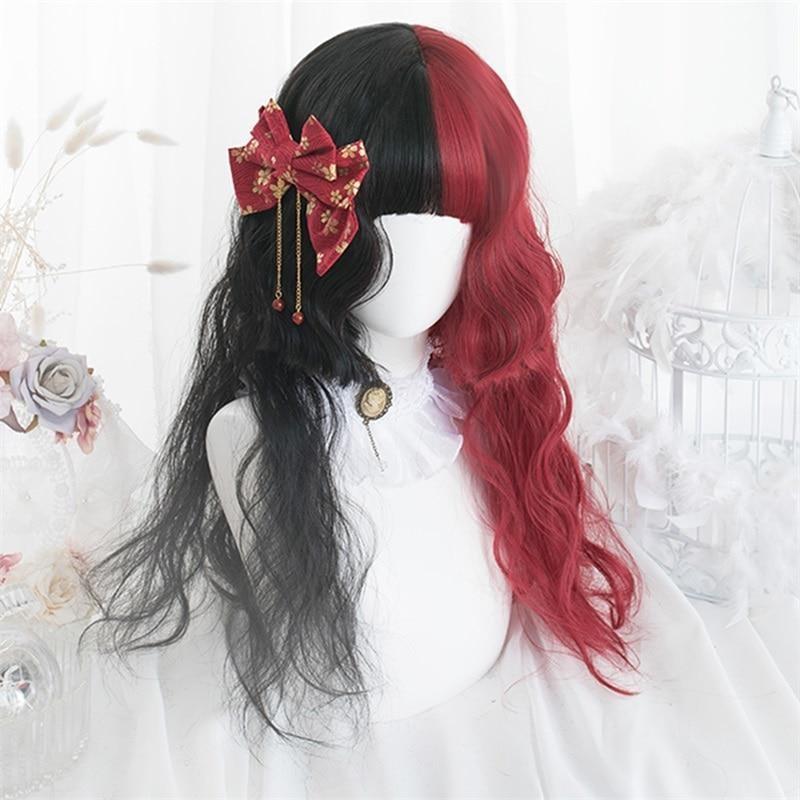 Black-and-red split-color wig with loose waves and full bangs, styled on a white mannequin with a red-and-gold bow and hanging ornaments at one side.