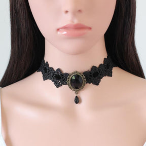 Black lace choker with an ornate oval centerpiece and hanging teardrop in the Black option, shown around a mannequin neck.